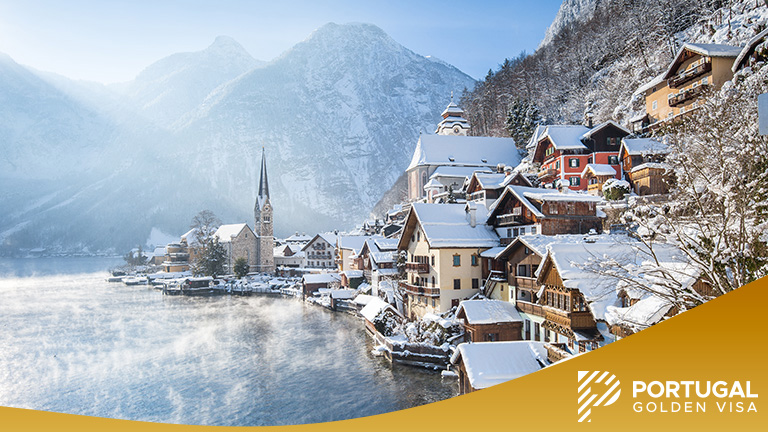 Classic postcard view of famous Hallstatt lakeside town in the Alps on a beautiful cold sunny day with blue sky and clouds at sunrise in winter, Salzkammergut region, Austria