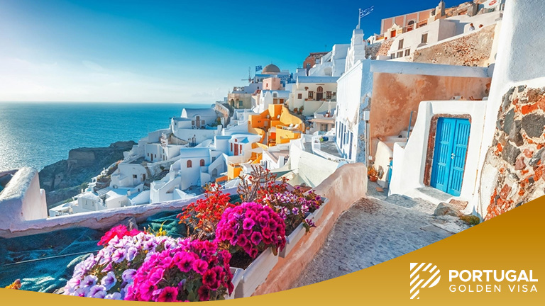 Santorini, Greece. Picturesq view of traditional cycladic Santorini houses on small street with flowers in foreground.